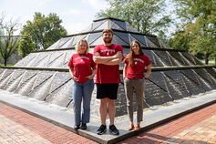 Three students standing in front of a fountain on the IU Indianapolis campus.